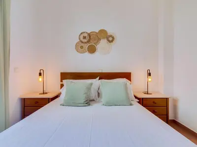 a bedroom with a white bed with two night stands at AL - Apartamento Maré Baixa in Quarteira