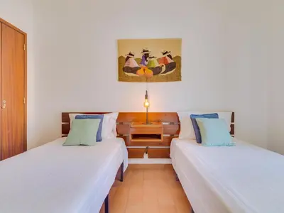 two beds in a room with white walls at AL - Apartamento Maré Baixa in Quarteira