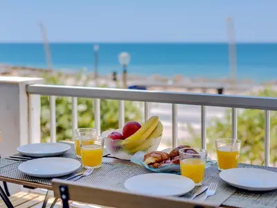 a table with plates of fruit and glasses of orange juice at AL - Apartamento Maré Baixa in Quarteira