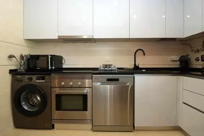 a kitchen with a stove and a washing machine at Millennium golf by FHR piscina & parking in Vilamoura