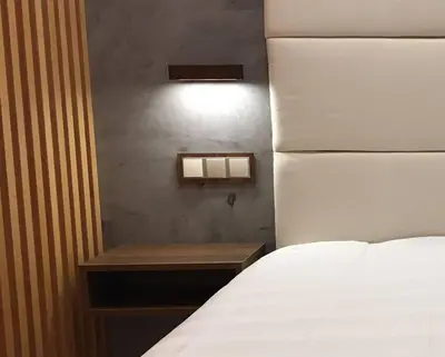 a bedroom with a white bed and a nightstand next to a bed sidx sidx at Great sea view apartment, near the beach, with AC and pools in Albufeira
