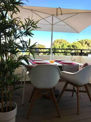 a table and chairs with an umbrella on a balcony at Great sea view apartment, near the beach, with AC and pools in Albufeira