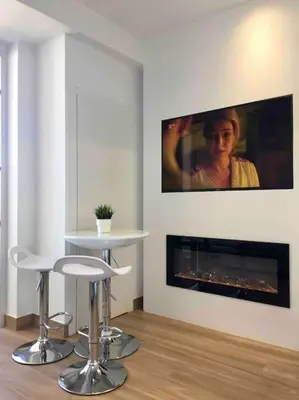 a living room with a table and a fireplace at Great sea view apartment, near the beach, with AC and pools in Albufeira