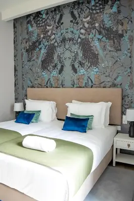 a bedroom with two beds with blue pillows at Guest House Jacarandá Faro in Faro