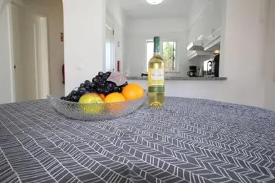 a bowl of fruit and a bottle of wine on a counter at The Sun - Clube Albufeira Garden Village in Albufeira