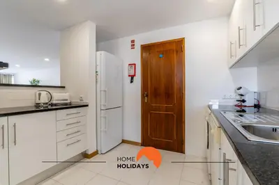 a kitchen with a sink and a wooden door at #169 T3 Medronheira by Home Holidays in Albufeira