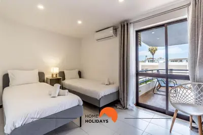 two beds in a room with a balcony at #169 T3 Medronheira by Home Holidays in Albufeira