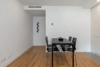 a dining room with a black table and chairs at Compromisso 25 in Faro