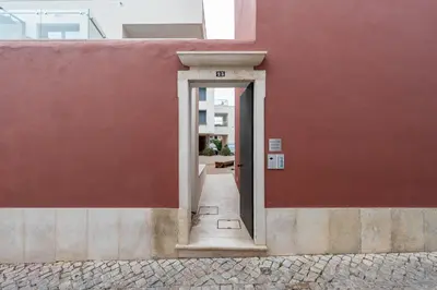 a doorway to a red building with a red wall at Compromisso 25 in Faro