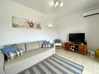 a living room with a couch and a flat screen tv at Vilamoura Twins 1 With Pool by Homing in Vilamoura