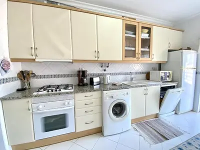 a kitchen with white cabinets and a washer and dryer at Vilamoura Typical 2 With Pool by Homing in Vilamoura
