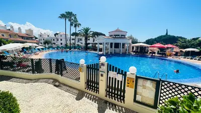 a large swimming pool with a fence around it at Charming triplex T2 in the Old Village Vilamoura in Quarteira
