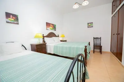 a hotel room with two beds and a chair at Casinha I by Innkeeper in Guia