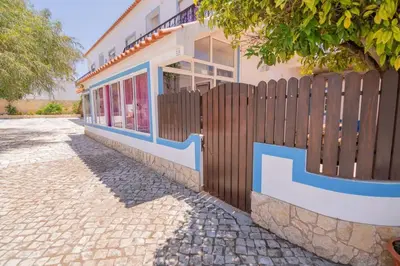 a building with a wooden fence next to a sidewalk at Casinha VII by Innkeeper in Guia