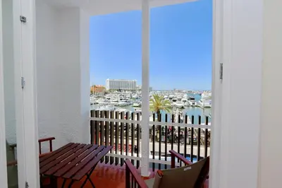 a balcony with a table and chairs and a view of a harbor at Marina Vista Sol-CleverDetails, Marina view, sleeps 2 adults and 2 children in Vilamoura