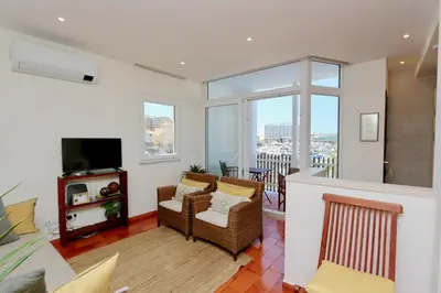 a living room with a couch and a television at Marina Vista Sol-CleverDetails, Marina view, sleeps 2 adults and 2 children in Vilamoura