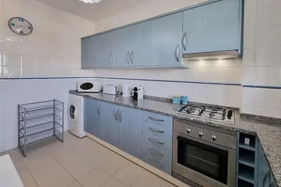 a kitchen with blue cabinets and a stove top oven at Sea Beside in Albufeira