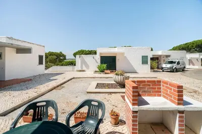 a patio with chairs and a brick fireplace at Sunny Villa with golf front view in Vilamoura