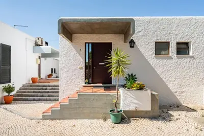 a front door of a house with a palm plant at Sunny Villa with golf front view in Vilamoura
