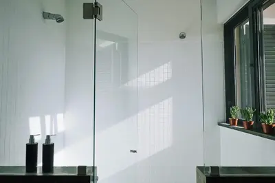 a shower with a glass door in a bathroom at CASA AMOR JACARANDA - Ocean View Modern Vila in Albufeira