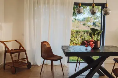 a dining room with a table and chairs and a window at CASA AMOR JACARANDA - Ocean View Modern Vila in Albufeira