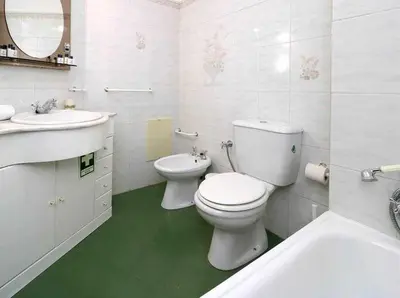 a white bathroom with a toilet and a sink at Mar á vista by FHR 2 minutos á praia in Quarteira