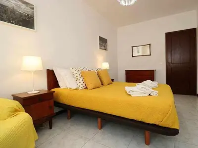 a bedroom with two beds with yellow sheets at Mar á vista by FHR 2 minutos á praia in Quarteira