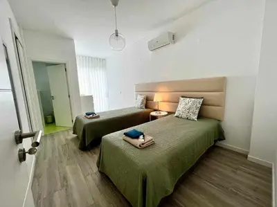 a hotel room with two beds with green sheets at Anzol By FHR in Quarteira