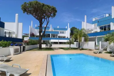 a person swimming in a swimming pool next to a building at Anzol By FHR in Quarteira