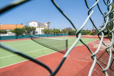 a view of a tennis court from behind a net at Villa Arrifes by Atlantic Places in Albufeira
