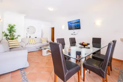 a living room with a glass table and chairs at Villa Arrifes by Atlantic Places in Albufeira