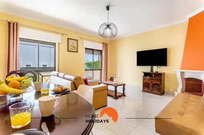 a living room with a table and a tv at #180 T2 Ondas do Mar by Home Holidays in Albufeira