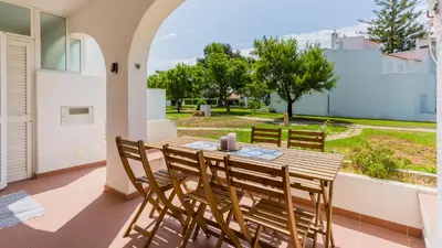 a wooden table and chairs on a balcony at 1 BDR Vilamoura Escape W Patio by LovelyStay in Quarteira