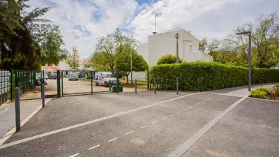 a parking lot with a fence and a building at 1 BDR Vilamoura Escape W Patio by LovelyStay in Quarteira