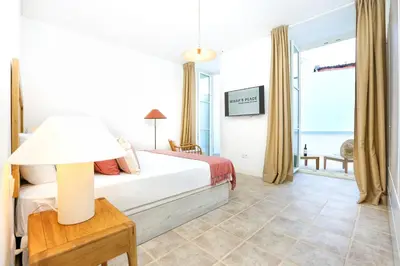 a bedroom with a bed and a table with a lamp at Doce Faro Niente Apartment in Faro