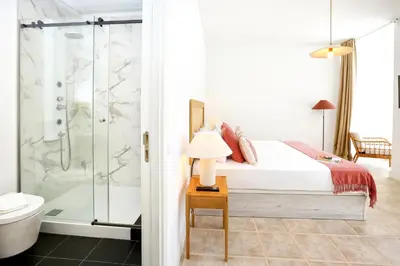 a bedroom with a bed and a shower at Doce Faro Niente Apartment in Faro