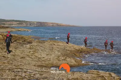 a group of people walking on the rocks near the water at #178 Monte das Churras 1 by Home Holidays in Albufeira