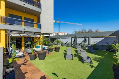 a patio with chairs and plants on a building at Stunning Exclusive Parque Atlântico in Quarteira