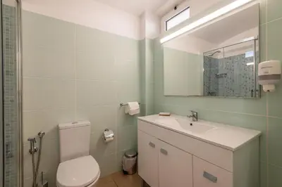 a bathroom with a toilet and a sink and a mirror at Albufeira Jardim Studio with Sea View - Free Wi-Fi - Pool in Albufeira