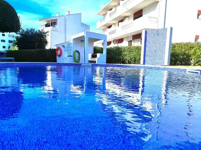 a large blue swimming pool in front of a building at Vilamoura Twins 2 With Pool by Homing in Vilamoura