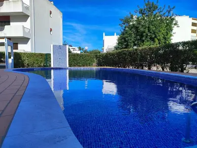 a large blue swimming pool next to a building at Vilamoura Twins 2 With Pool by Homing in Vilamoura