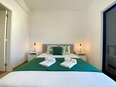 a bedroom with a large bed with two towels on it at Vilamoura Twins 2 With Pool by Homing in Vilamoura