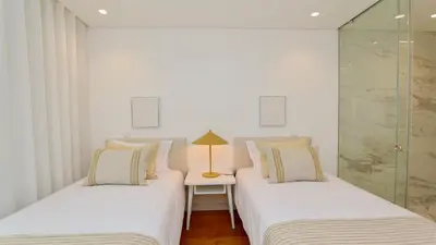 two beds in a room with a lamp on a table at Lake24 CD256- CleverDetails, 3 bedroom apartment, sleeps 6, near to Falesia Beach and the Marina in Vilamoura