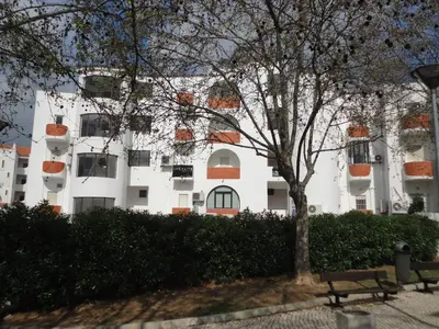 a white building with a tree in front of it at Original Apartments in Albufeira