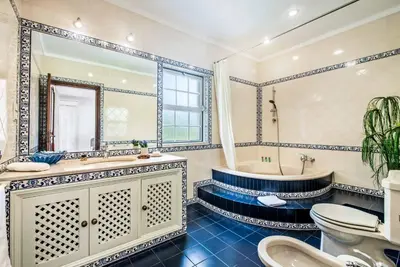 a bathroom with a tub and a sink and a toilet at Villa Vargues in Quarteira