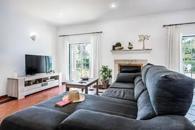 a living room with a large couch and a tv at Villa Vargues in Quarteira