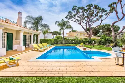 a swimming pool in the backyard of a house at Villa Vargues in Quarteira