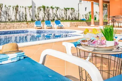 a table and chairs next to a swimming pool at Villa Luis in Galé