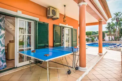 a ping pong table on the patio of a house at Villa Luis in Galé