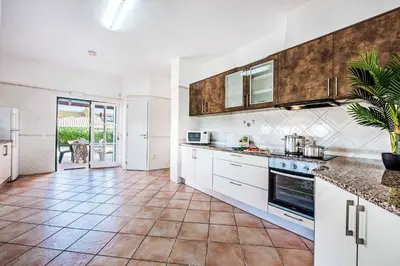 a kitchen with white cabinets and a tile floor at Villa Luis in Galé
